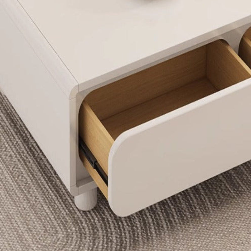 Close-up of a white desk with an open drawer on a gray carpeted floor.